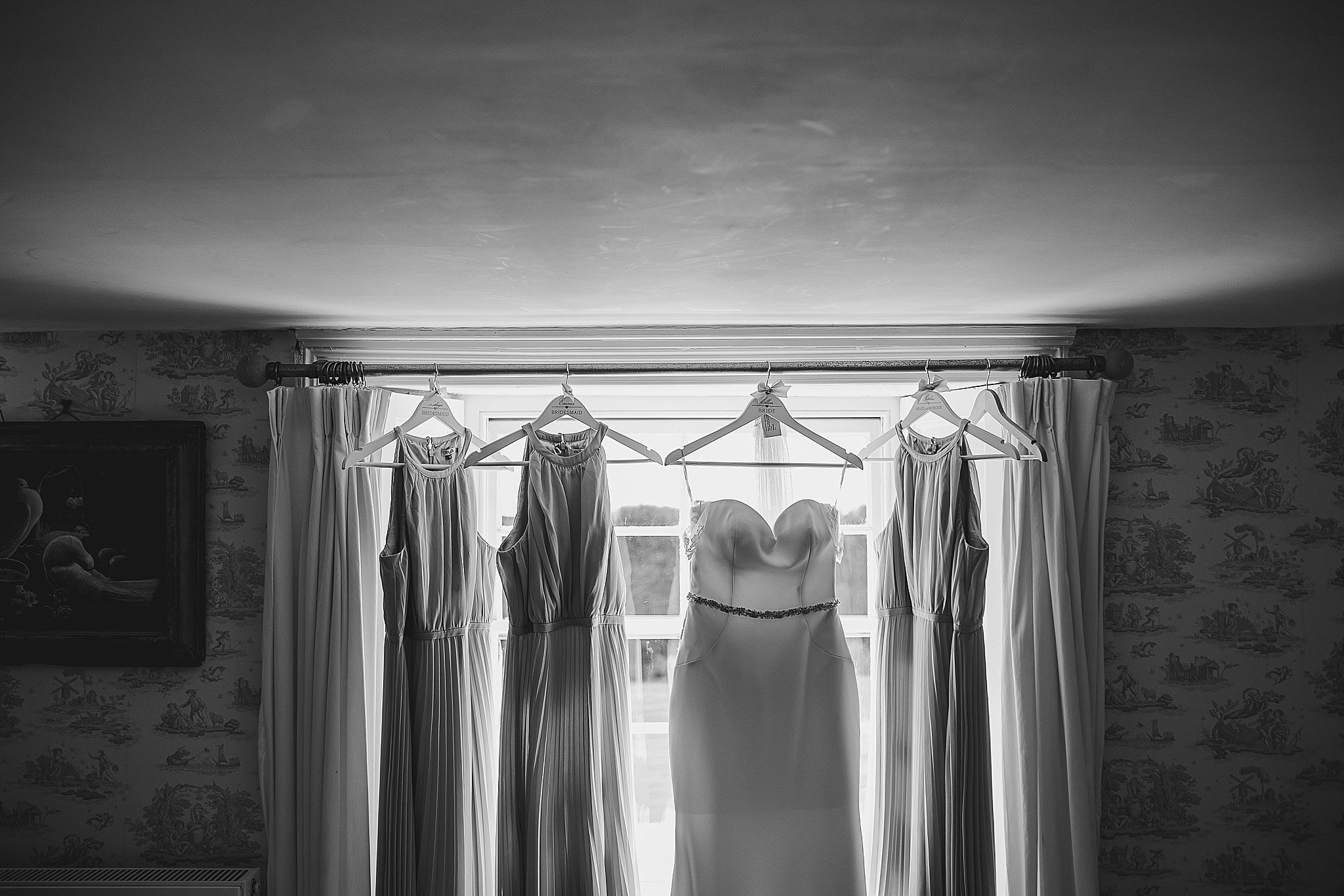 Wedding Dress Hanging up with bridemaids dresses